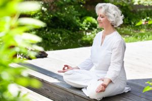 Frau meditiert im Garten