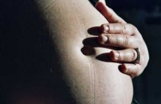 Schwangerer Bauch mit Hand
