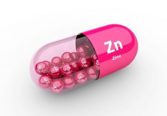 Große pinke Zn-Pille, gefüllt mit Kügelchen, auf denen Zn steht.