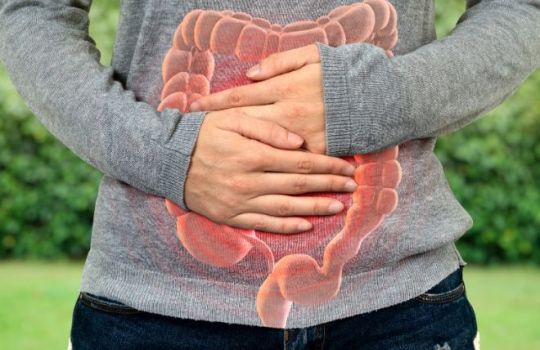 Frau hält wegen Leaky Gut Hände vor den Bauch. 