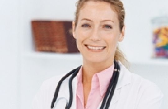 Eine junge Ärztin lächelt in die Kamera.