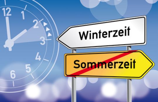 Zwei Richtungsschilder, auf denen Sommer- und Winterzeit steht, sind zu sehen.