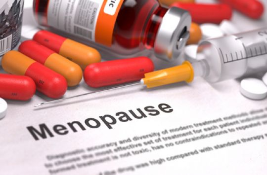 Pillen, Spritzen und weitere Arzneimittel liegen auf einem Zettel, auf dem Menopause steht.