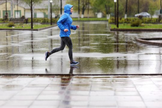 Joggende Person in Regenkleidung draußen.