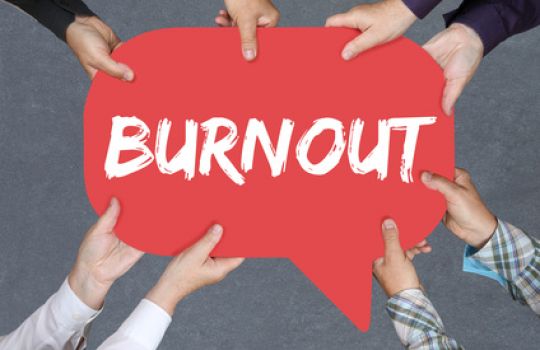 Vier Paar Hände halten rotes Schild mit Aufdruck: Burnout.