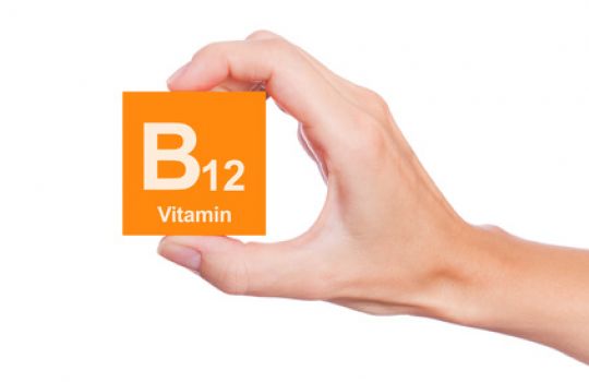 Hand hält Würfel auf dem B12 Vitamin draufsteht
