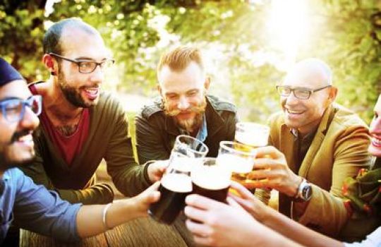 Eine Gruppe Männer stößt mit Bier an.