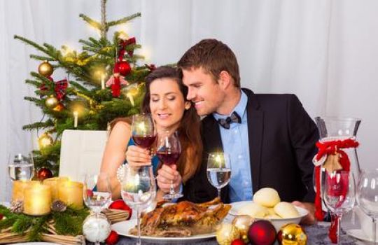 Ein Paar sitzt am Tisch bei einem Weihnachtsessen mit Gans.